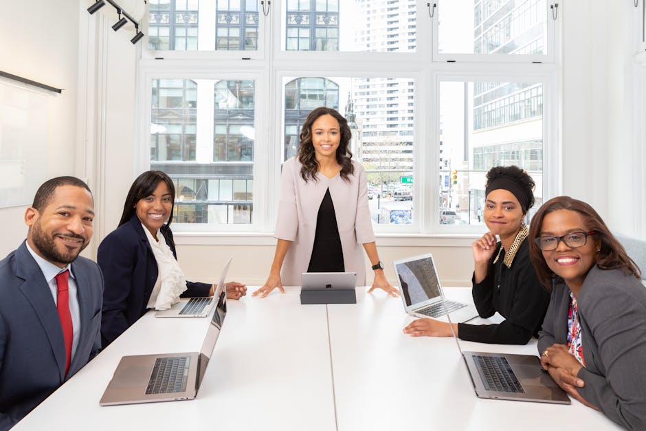 A confident businesswoman leading a diverse group in a modern corporate boardroom