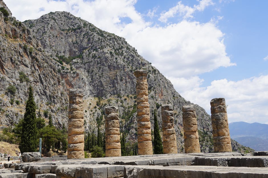 The ancient ruins of Delphi nestled on the slopes of Mount Parnassus, with the Temple of Apollo prominent in the foreground