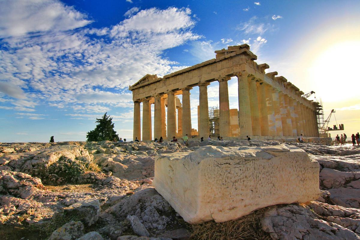 The Parthenon standing majestically atop the Acropolis in Athens, with its iconic Doric columns illuminated by warm sunlight